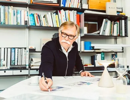 Ein Mann mit Brille und schwarzem Hemd arbeitet an einem Projekt