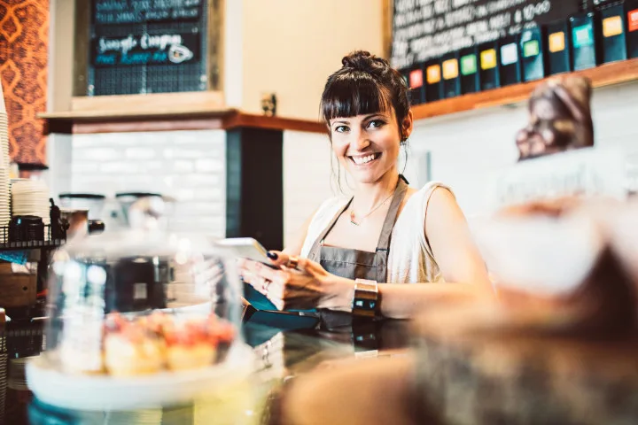 Frau lächelt bei der Arbeit in einem Café.