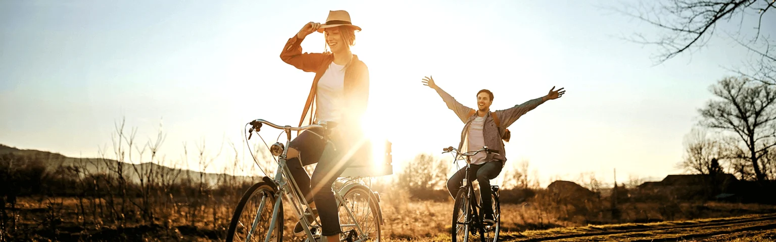 Mann und Frau fahren bei Sonnenuntergang Fahrrad