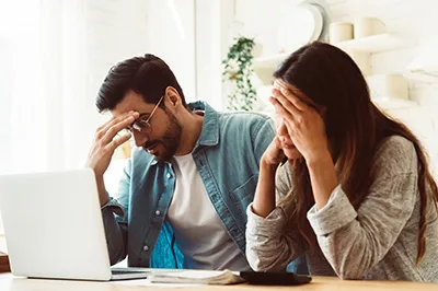 2 Personen Grübelnd vor dem Laptop