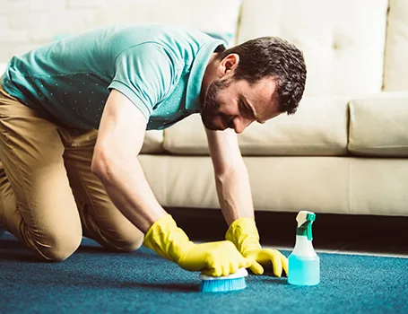 Mann putzt einen Teppich