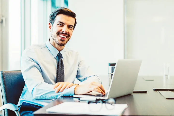 Mann arbeitet glücklich am Laptop